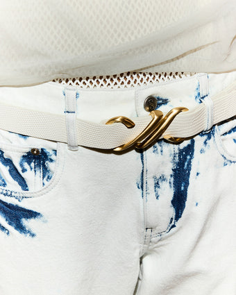 close crop of acid wash Ellsworth denim and gold hardware monogram belt