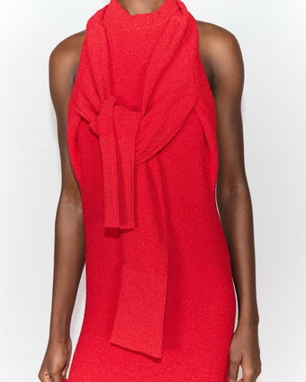 Cropped image of a model wearing the red Lara Dress with sleeves tied across her chest