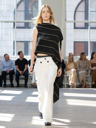 Image of model walking Proenza Schouler SS25 Runway wearing Sutton Top in Stripe Bi-Stretch Viscose in Black Multi and Oliver Pant in Wool Gabardine in Off White and Glove Shoe in BLACK