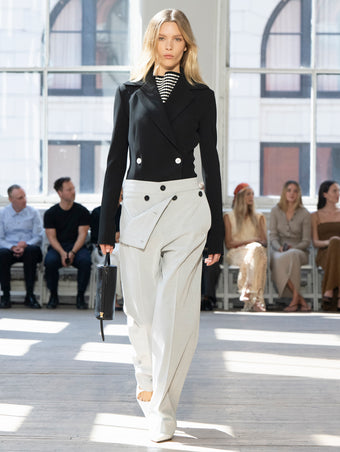 Image of model walking Proenza Schouler SS25 Runway wearing Marine Jacket in Bi-Stretch Viscose in Black and Prescott Top in Matte Viscose Crepe in Black Multi and Oliver Pant in Technical Herringbone  in Smoke and Silo Bag in Black Nappa  in BLACK and Slash Slingback Pump in WHITE