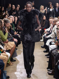 Model Walking in Proenza Schouler Fall Winter 2024 Runway Show Wearing Aubrey Vest in Black Toscana, Teddy Pant in Black Double Weave Viscose Organza, and  Bronco Ankle Boots in Black Brushed Calf