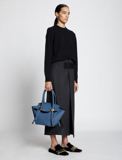 Image of model carrying Small Pipe Bag in dusty blue