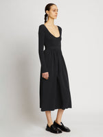 Side full length image of model wearing Rib Knit Long Sleeve Dress in BLACK