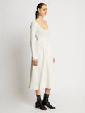 Side full length image of model wearing Rib Knit Long Sleeve Dress in OFF WHITE