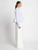 Side full length image of model wearing Eco Poplin Blouse in WHITE