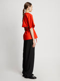 Side full length image of model wearing Poplin Drawstring Blouse in BRIGHT ORANGE