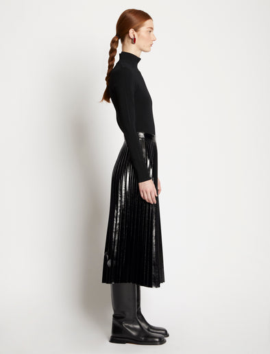 Side full length image of model wearing Lacquered Canvas Pleated Midi Skirt in BLACK