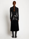 Back full length image of model wearing Lacquered Canvas Pleated Midi Skirt in BLACK