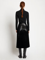 Back full length image of model wearing Lacquered Canvas Pleated Midi Skirt in BLACK