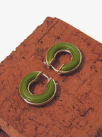 Image of mini hoop earrings in olive against brick