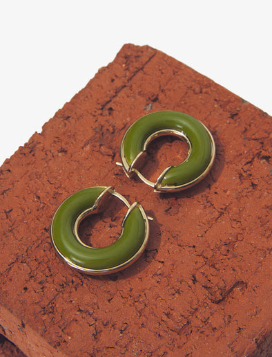 Image of mini hoop earrings in olive against brick