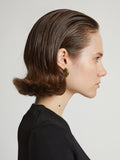 Image of model wearing mini hoop earrings in olive