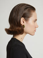 Image of model wearing mini hoop earrings in olive