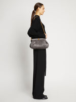 Image of model wearing Rolo Frame Clutch Bag in STONE