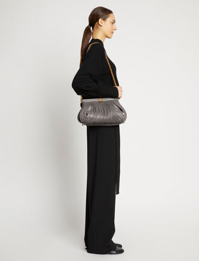 Image of model wearing Rolo Frame Clutch Bag in STONE