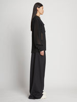 Side full length image of model wearing Sheer Pleated Flou Top in BLACK