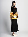 Image of model wearing Metallic Drawstring Tote in GOLD