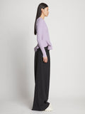 Side full length image of model wearing Fluted Rib Knit Peplum Sweater in LAVENDER