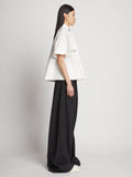 Side full length image of model wearing Poplin Pintuck Top in WHITE