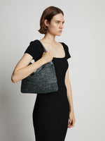 Image of model carrying Minetta Raffia Bag in dove grey