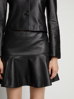 Detail image of model wearing Leather Ruffle Mini Skirt in black