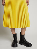 Detail image of model wearing Faux Leather Pleated Midi Skirt in sun