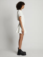 Side image of model wearing Faux Leather Ruffle Mini Dress in off white