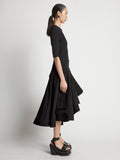 Side image of model wearing Technical Nylon Wrap Skirt in black