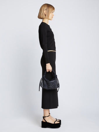 Image of model carrying Studded Small Ruched Handle Bag in DARK NAVY