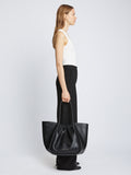 Image of model carrying Carved Python XL Ruched Tote in BLACK in hand