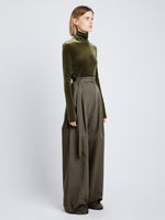 Side full length image of model wearing Stretch Velvet Turtleneck Top in MILITARY