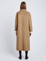 Back full length image of model wearing Reversible Double Face Coat in CAMEL / OFF WHITE on CAMEL side