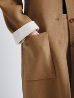 Detail image of model wearing Reversible Double Face Coat in CAMEL / OFF WHITE on CAMEL side