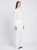 Side full length image of model wearing Chunky Cable Bell Sleeve Sweater in OFF WHITE