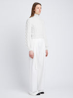 Side full length image of model wearing Chunky Cable Bell Sleeve Sweater in OFF WHITE