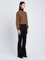 Side full length image of model wearing Chunky Cable Bell Sleeve Sweater in DARK CAMEL