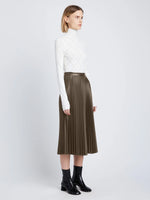 Side image of model wearing Faux Leather Pleated Skirt in wood