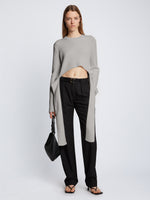 Front full length image of model wearing Ribbed Cotton Wrap Sweater in GREY MELANGE with straps hanging by sides