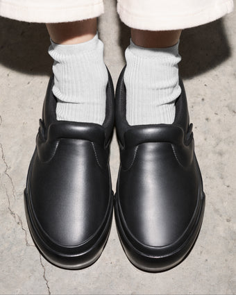 Aerial image of model wearing Vans x Proenza Schouler Puffy Slip-On Shoes in black