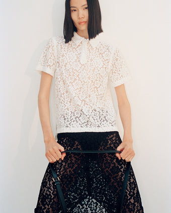 Cropped image of model wearing Kennedy Top in Stretch Lace in off white and Jasmine Skirt in Stretch Lace in black