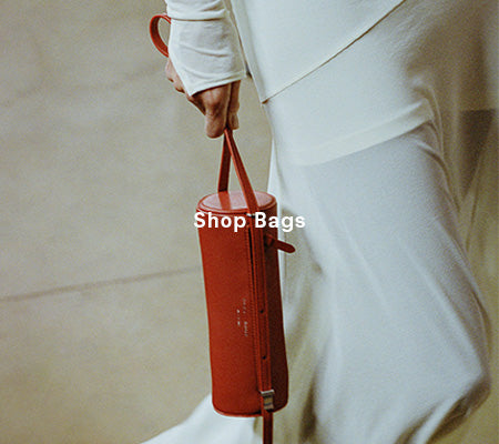 Cropped image of model carrying Silo Bag in rosewood, 'Shop Bags' overlaid