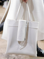 Proenza Schouler runway image of model carrying Silo Bag in Ostrich Embossed Calf in CREAM