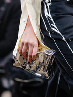 Proenza Schouler runway image of model carrying Crush Clutch in SILVER