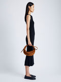 Image of model wearing Slide Bag in Soft Suede in SADDLE