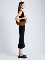 Image of model wearing Slide Bag in Soft Suede in SADDLE