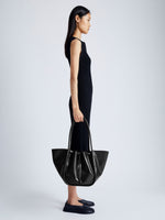 Image of model carrying Large Ruched Tote in Soft Shiny Calf in BLACK