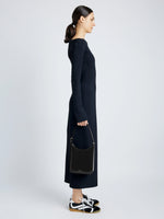 Front full length image of model holding Slope Shoulder Bag In Soft Spazzolato in BLACK