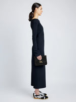 Front full length image of model holding Box Bag in Box Calf in BLACK