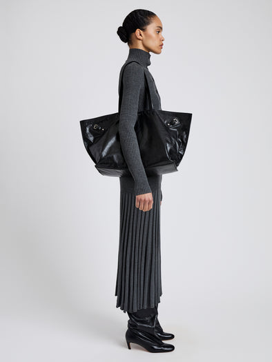 Proenza Schouler image of model carrying Days Carryall in Paper Calf in black