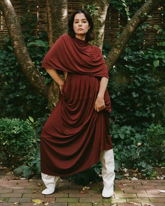 Image of Parker Posey wearing Frankie Dress in Matte Jersey in oxblood and Tee Knee High Boots in white